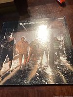 Photo showing The Who vinyl record cover titled 'The Best of The Greatest Hits' with band members in sunlight