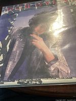 Front cover of Bob Dylan Empire Burlesque vinyl LP showing Bob Dylan in a patterned jacket.