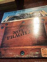 Front cover of the Bachman Turner Overdrive record album "Not Fragile" showing wooden crate design with gears and 'Not Fragile' text.