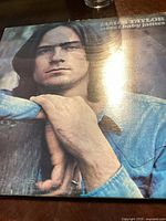 Front cover of James Taylor 'Sweet Baby James' vinyl record album featuring portrait of James Taylor.