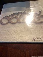 Front cover of the anthology vinyl record album by The Band showing the embossed logo in beige.