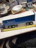 Side view of large Sears transport truck toy showing logo and trailer with measuring tape for size reference.
