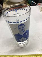 Photo showing a front view of the glass with an image of Tim Horton in Toronto Maple Leafs jersey, surrounded by blue maple leaves at the rim.