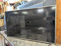 Front view of LG 42-inch TV showing the screen and attached wall mounting bracket on top with visible dust.