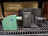 Photo showing the side view of the two vintage slide projectors, highlighting their size and shape.