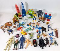 Overview of about 40 assorted vintage plastic toys and action figures including characters from Star Wars, McDonald's Happy Meal toys, novelty figures, and colorful creatures.