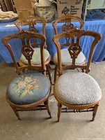 Set of four Victorian style oak wooden chairs with upholstered seats in floral tapestry fabric, showing overall condition and style.