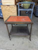Front view of vintage wooden bar cart featuring red tiled top and lower shelf, showing overall condition and tile top wear.