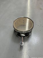 11 inch drum with black finish and chrome mounting hardware, clear drumhead with wear marks.