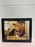 Front view of framed farmhouse style picture featuring cow, dog, and chickens with barn background.