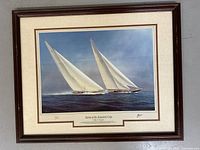 Full view of large framed art print showing two white sailing yachts on blue sea under sky. Print signed Tim Thompson and framed in dark wood with double matting.