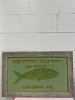 Front view of the framed canvas painting featuring a green fish and text 'Fish Stories Told Here No Charge Lakeshore Pub'.