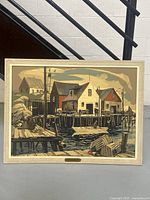 Framed print showing coastal scene of wooden docks and cottages