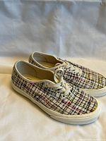 Side view of pair of Vans Authentic shoes showing woven plaid pattern and white soles