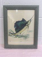 Framed artwork showing a sailfish jumping out of water, signed by Fred Sweeney and numbered 238.