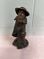 Front view of vintage clay sculpture, showing detailed face and posture of traveling beggar.