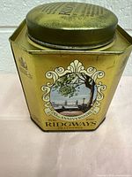Front and top view of vintage Ridgways tea tin showing tree and waterfront anniversary artwork