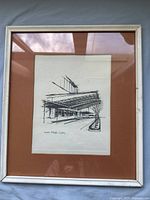 Framed artwork showing the complete vintage screen print with brown matte and white wooden frame.