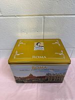 Side view of vintage Matilde Vicenzi tin box showing Roma Italy design with Roman landmarks illustration.