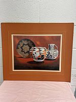 Full view of the vintage print showing three pottery vessels and the mat with some corner damage.