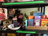 Shelf showing bulb boxes, boot planter, castle tower, miniature houses and figurines