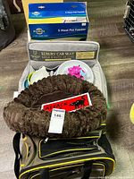 Group image showing boxed PetSafe feeders, car seat, carrier, bed, feeding dish, mat, scoop and sign