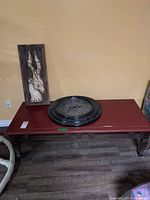 Coffee table with wall hanging and clock displayed on top