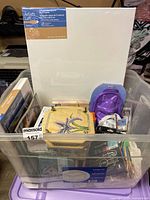 Overall tote view with canvas, wooden box, mask, books