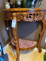 Front angle view showing carved floral apron, marble lower shelf, legs, overall condition