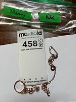 Ring, necklace, plastic bag labelled Disney 10K