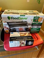Front of sealed retail box showing FoodSaver FM5200 2-in-1 vacuum sealing system