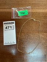 Full view of the gold chain necklace alongside lot tag