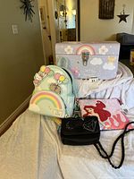 Group shot showing Sanrio backpack, rainbow trunk, Steve Madden purse, Ariel pouch