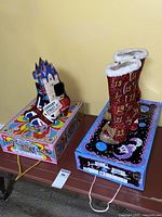 Two pairs of novelty boots displayed on their boxes