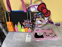 Overview showing all three items: Irregular Choice tote, Hello Kitty round bag, pink pouch