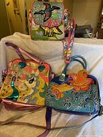 Front view of three handbags showing designs and detachable straps