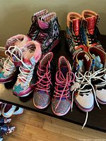 Five pairs of Irregular Choice high-top sneakers on table