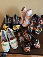 Six pairs of Irregular Choice shoes displayed on table