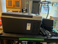 Side view of JoyTutus portable car refrigerator/freezer showing vents and overall exterior