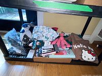 Shelf view showing Bissell steamer, attachments, assorted clothing, pink tools, teal box