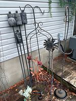 Group shot of tiki torches, shepherd hooks, sun wind chime, rose stakes