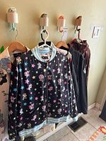 Front view of Tokidoki star-print bomber plus other jackets on hangers