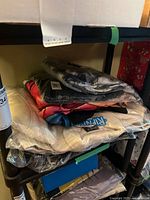 Stack of four poly-bagged garments including visible white RIPNDIP logo sweatshirt