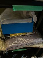 Blue shoe box atop packaged sweaters