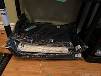 Stack of three sealed Ripndip garments under desk