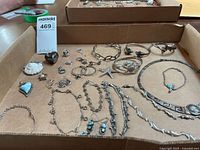 Tray showing multiple silver jewelry pieces including necklaces, bracelets, earrings, pendants