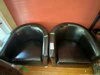 Front view of both brown leatherette tub chairs side-by-side