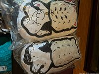 Two sealed Lord Nermal plush pillows stacked