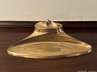 Top-down front angle showing brass inkwell with lid and pen tray recess