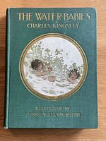 Front cover showing dark green cloth with gilt lettering and circular color illustration by Jessie Willcox Smith.